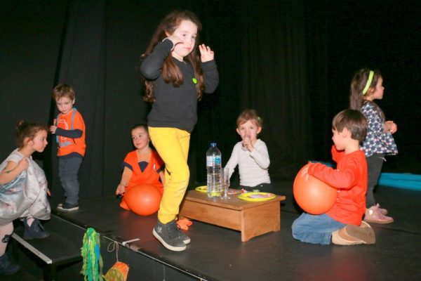 Sur la scène, les enfants attendent sagement.